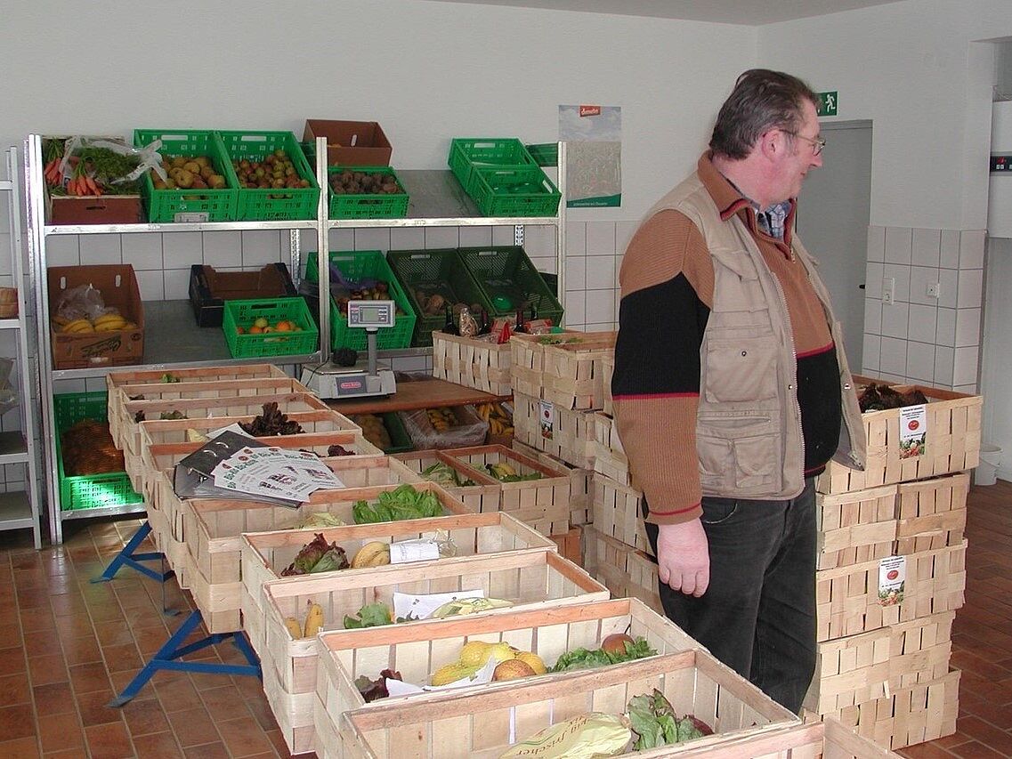 1997: Einführung der "Bio-Kiste" in Zusammenarbeit mit der Gärtnerei der Lebenshilfe (Rudi Oberländer vor Bio-Kisten in Martinsreuth)